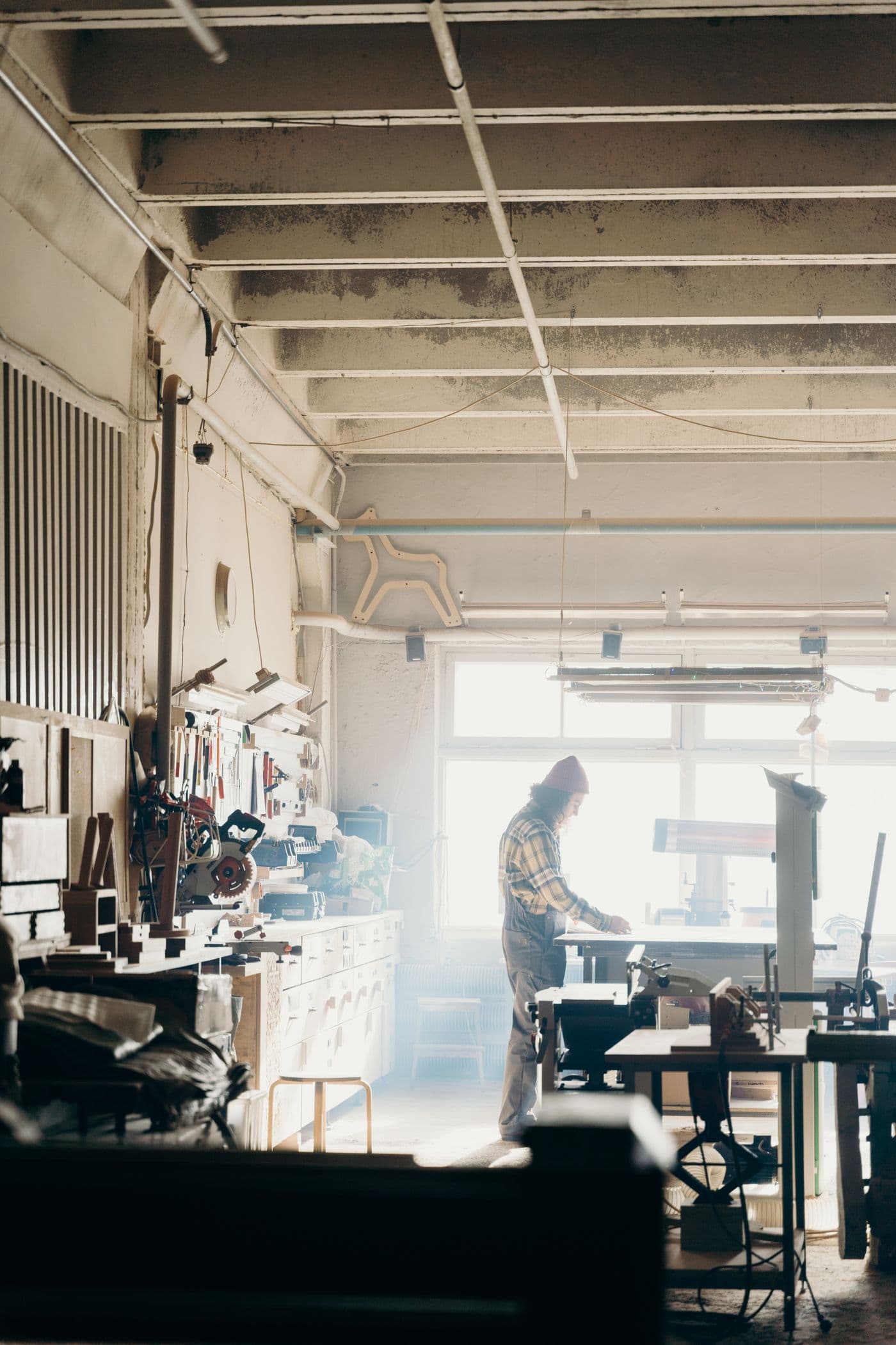 Carpenter working at a bench in a sunlit workshop