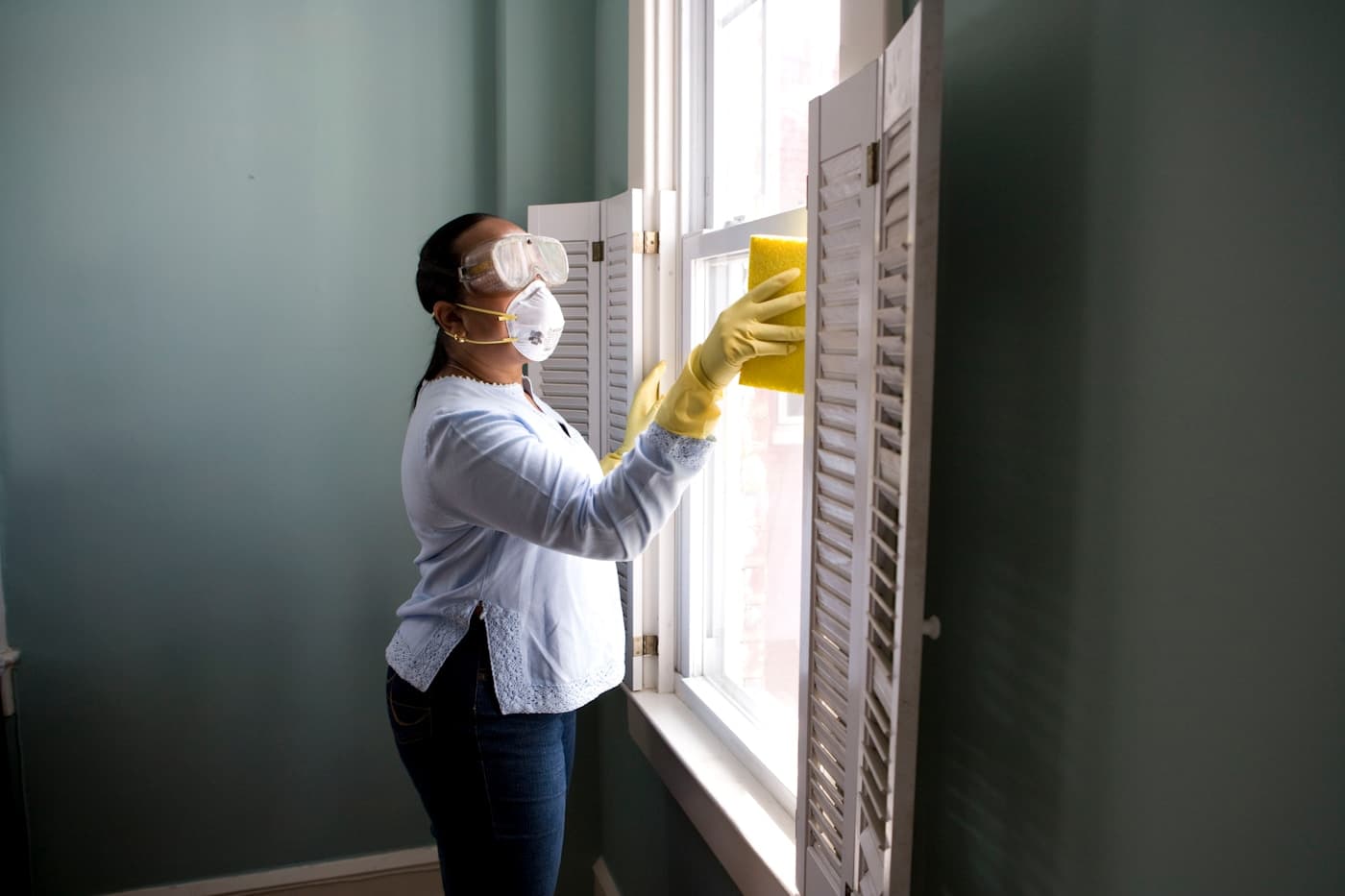 Cleaning professional polishing shutters in a bright modern home